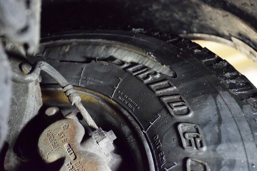 Your tires take a lot of abuse, and not all tire damage results in a flat tire, right away. In this photo, the tire has lost a portion of its sidewall—likely as a result of contact with a sharp rock in an off-road setting. Dangerously, this damage is on the inner tire sidewall, so it’s virtually invisible to the driver. Still holding air, the driver of this vehicle may never know that he has a severely damaged tire. The white stuff inside of the slit is the tire’s carcass, which you’re not supposed to be able to see. Remember to have a mechanic inspect your tires regularly, perhaps while you’re in for an oil change or tune-up.