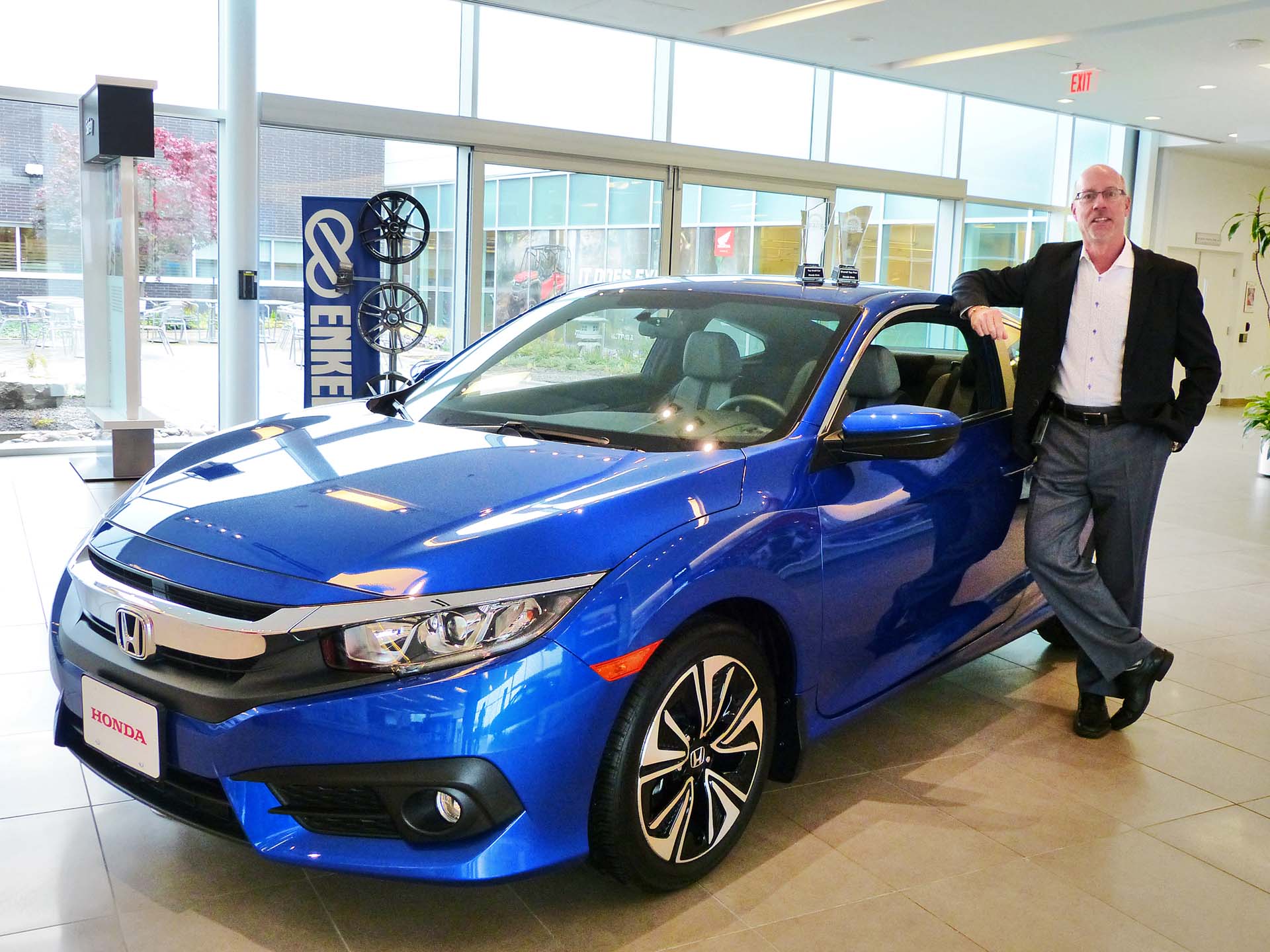 Honda Canada Senior Vice President, Operations, Dave Gardner, poses with the Honda Civic and his autoTRADER.ca Top Pick Trophies.
